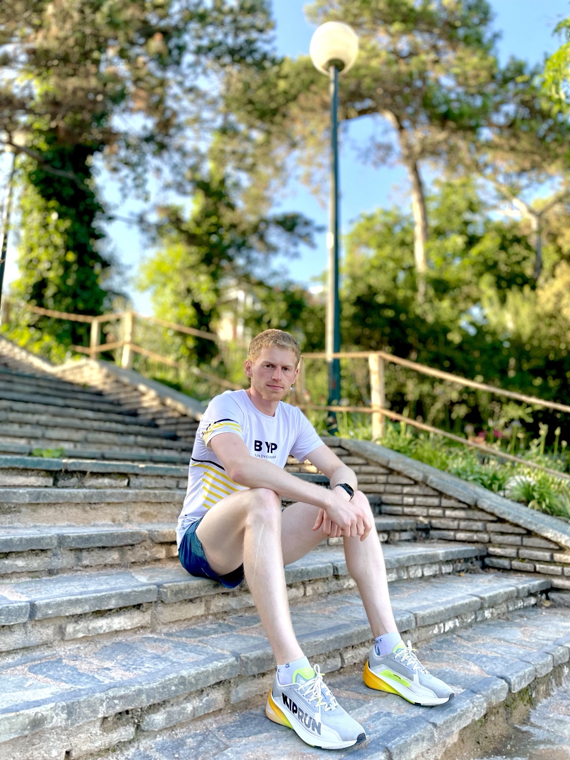 Timothée Durand assis sur des marches dans un parc.
